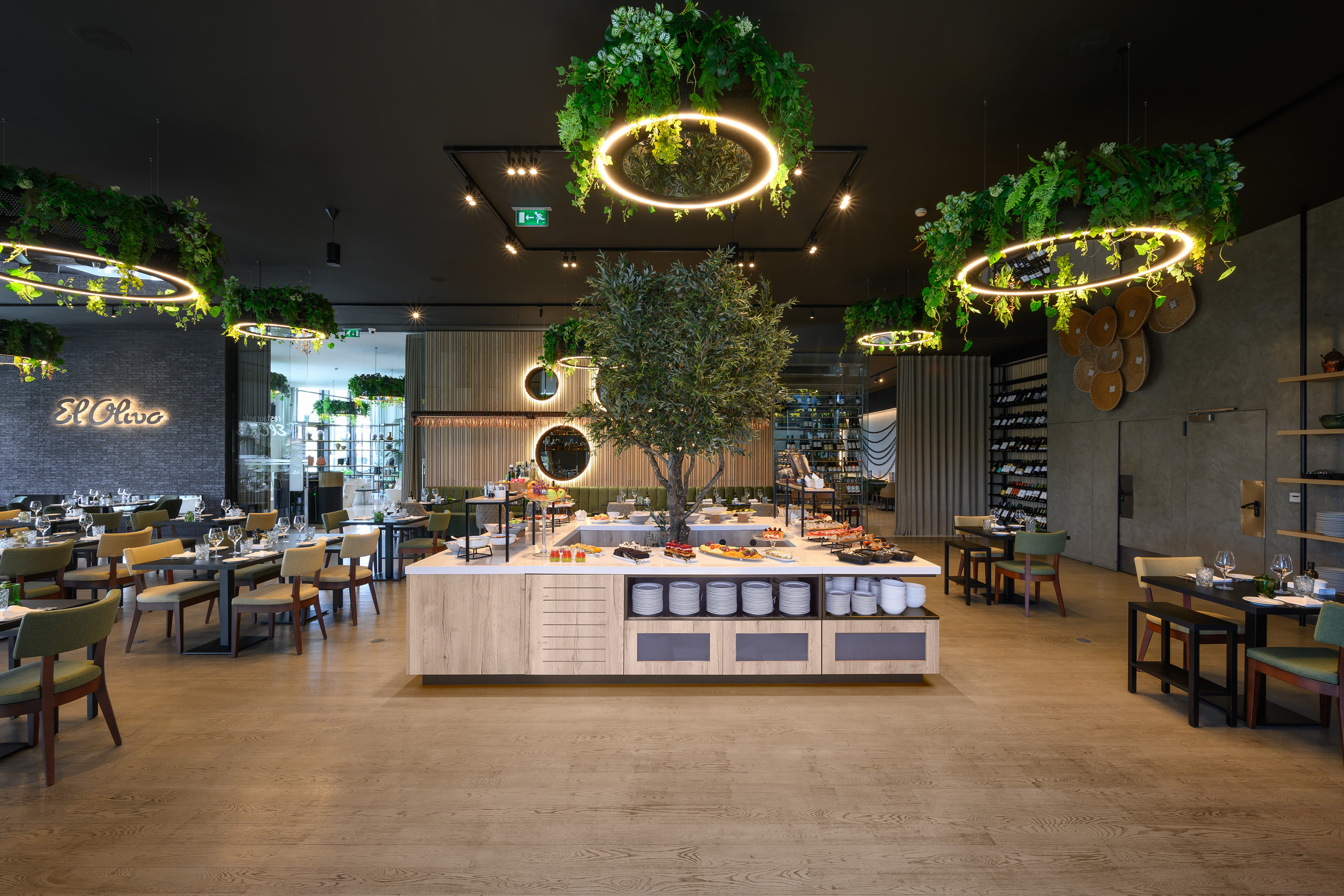El Olivo restaurant interior with buffet, olive tree, and stylish green lighting.