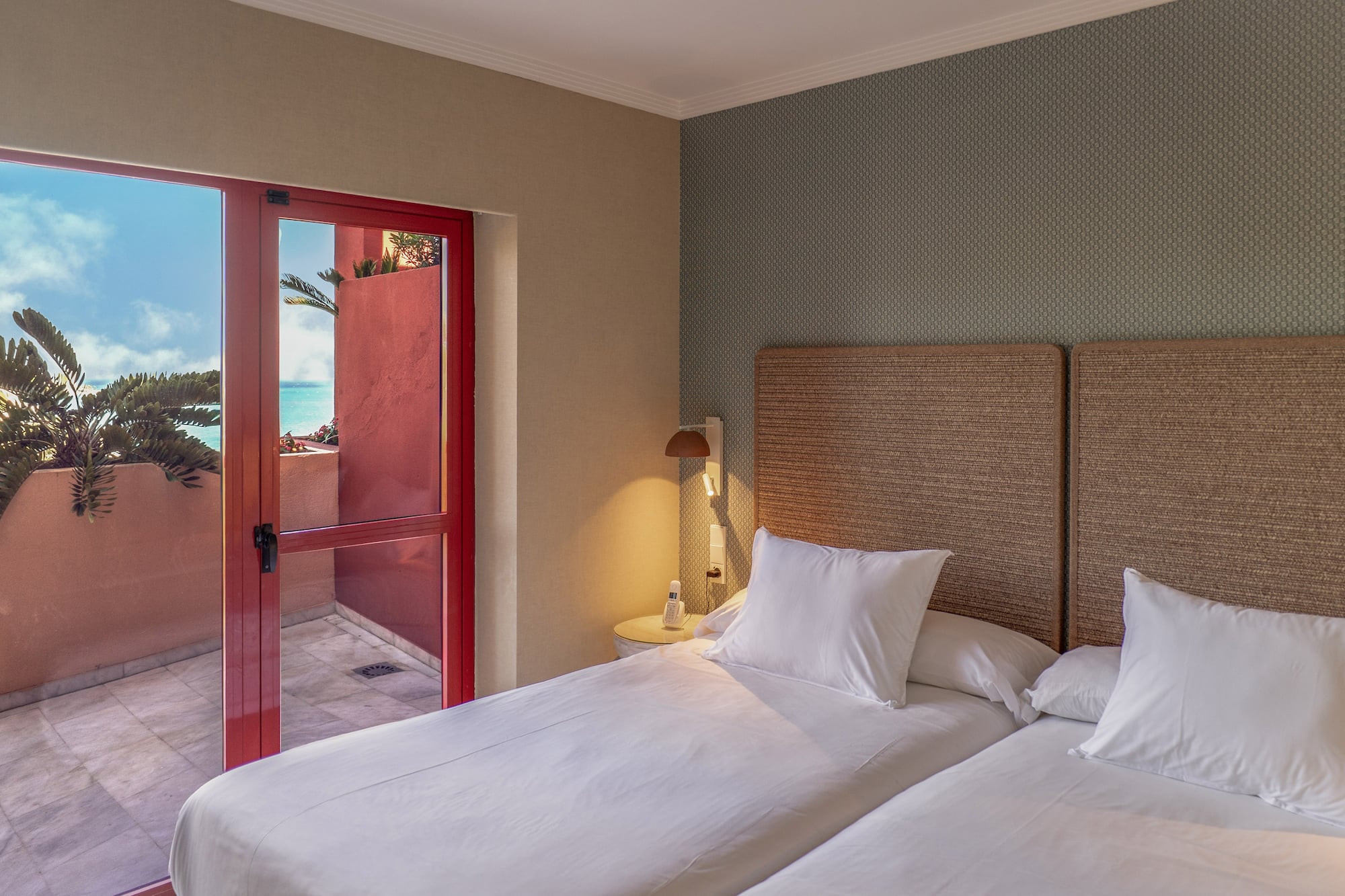 a room with two beds and a glass door