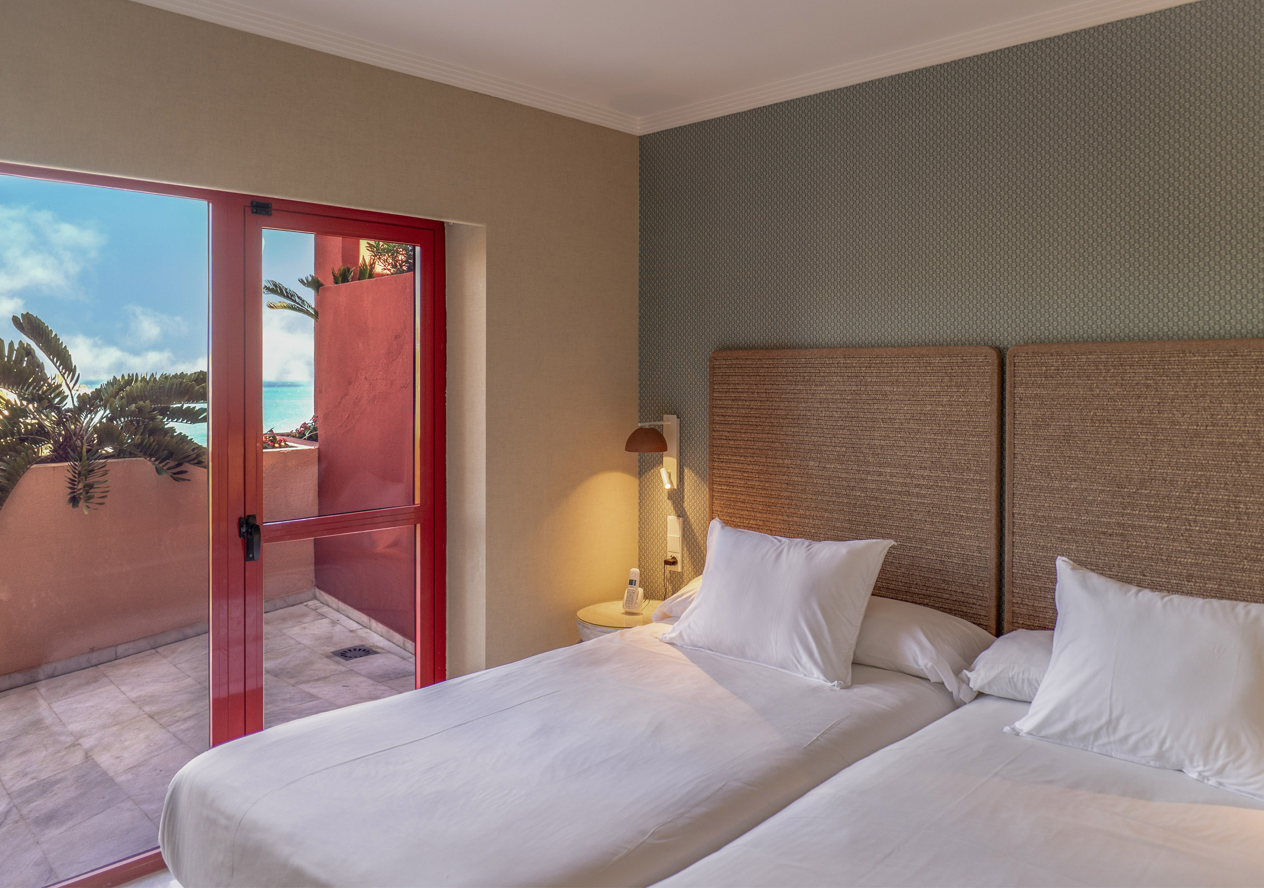 a room with two beds and a glass door