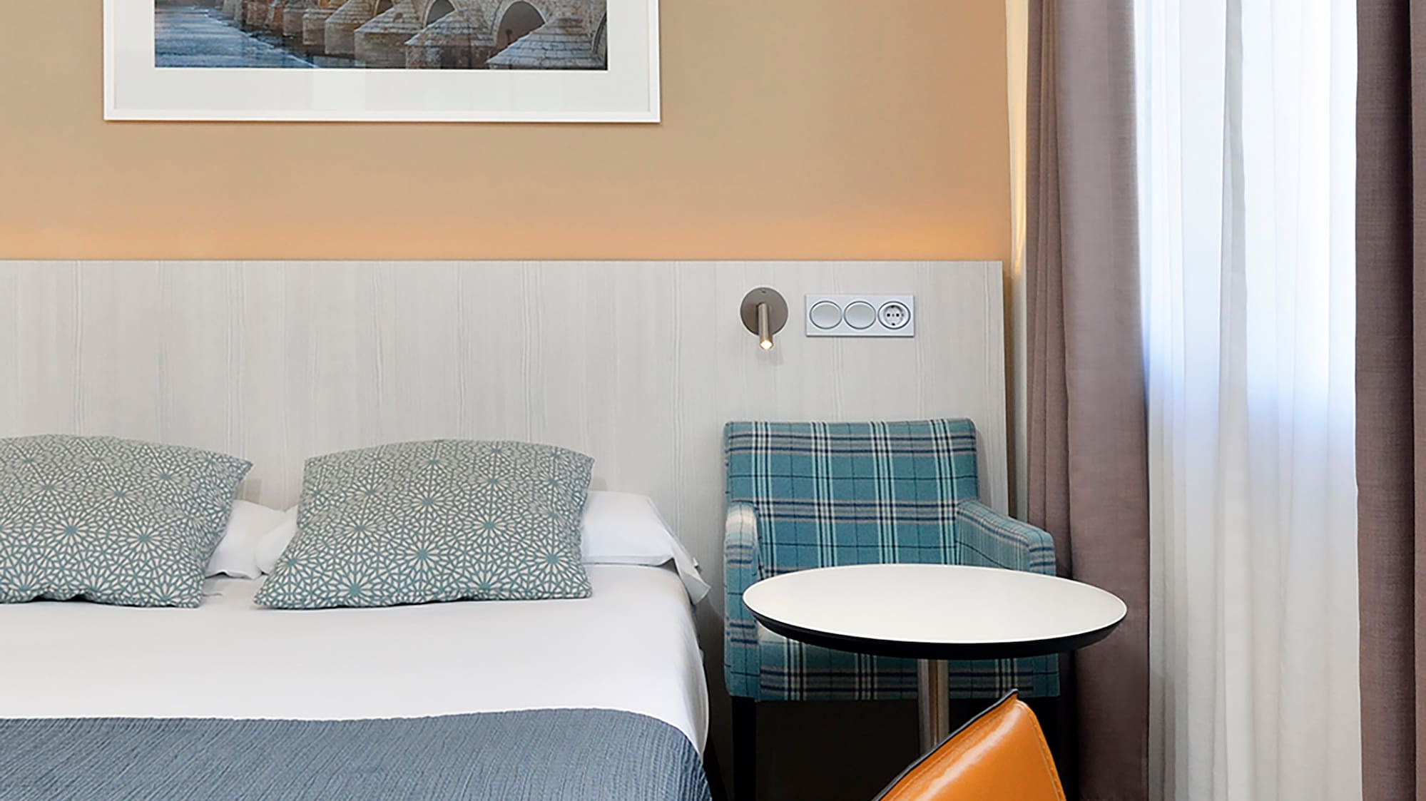 a bed with a table and chairs in a hotel room