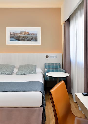 a bed with a table and chairs in a hotel room