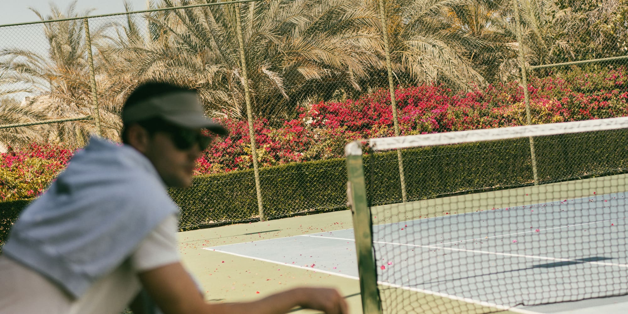 a man sitting on a bench with a tennis racket