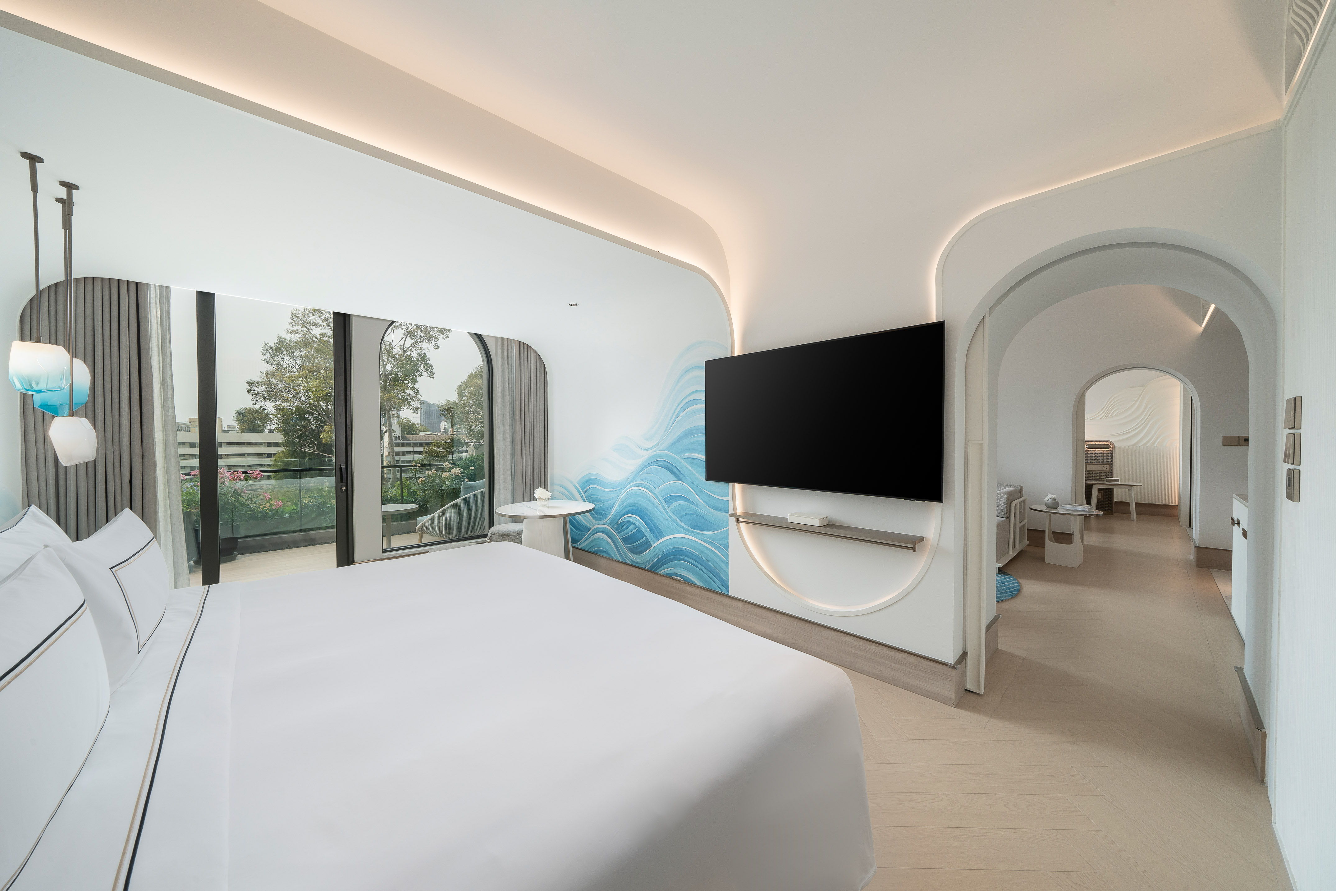 Modern hotel suite, blue wave wall art, white bed, TV, and balcony. - The Level 2 Bedroom Suite - Meliá Pattaya Hotel, Pattaya