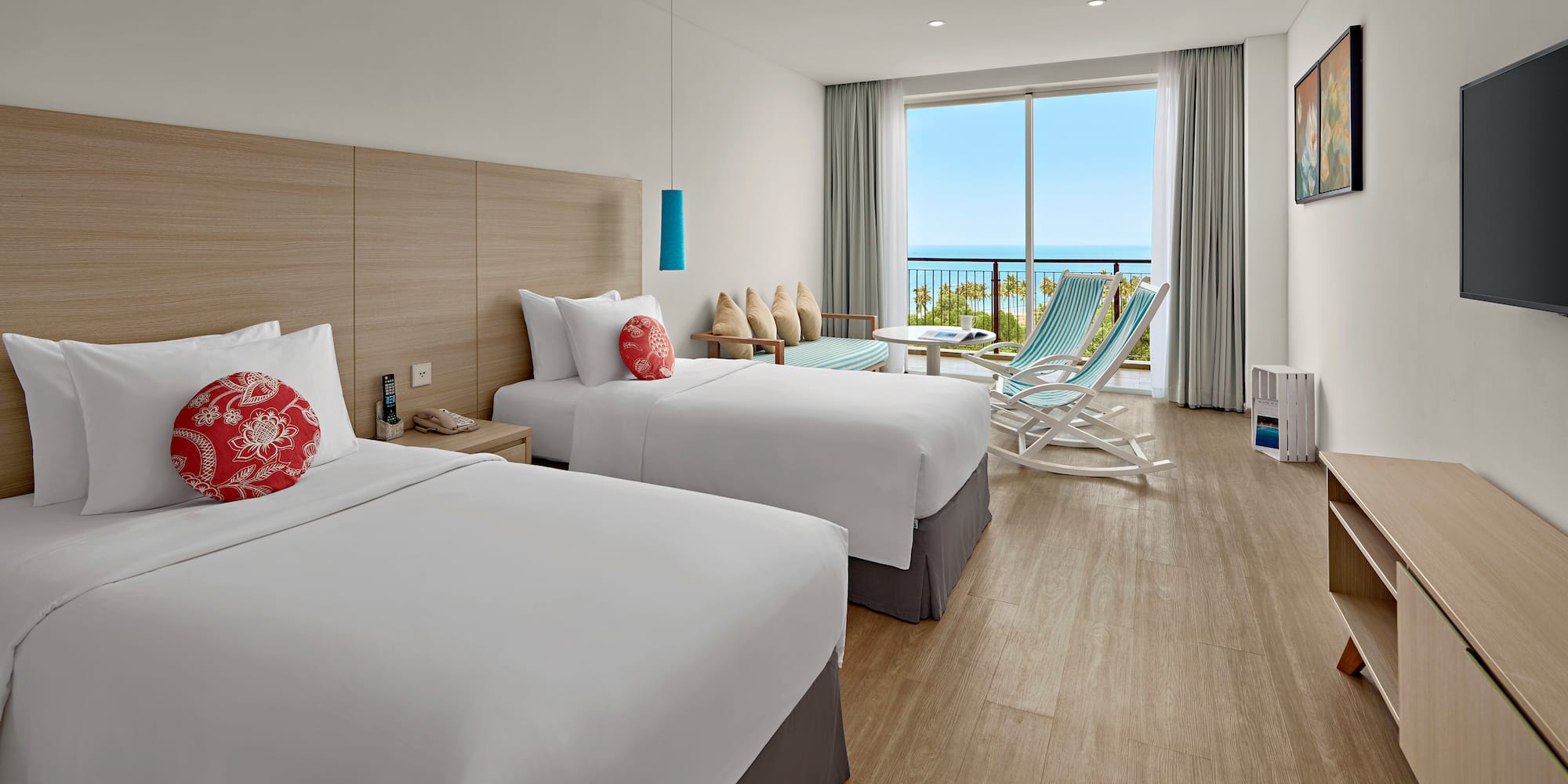 a room with two beds and chairs