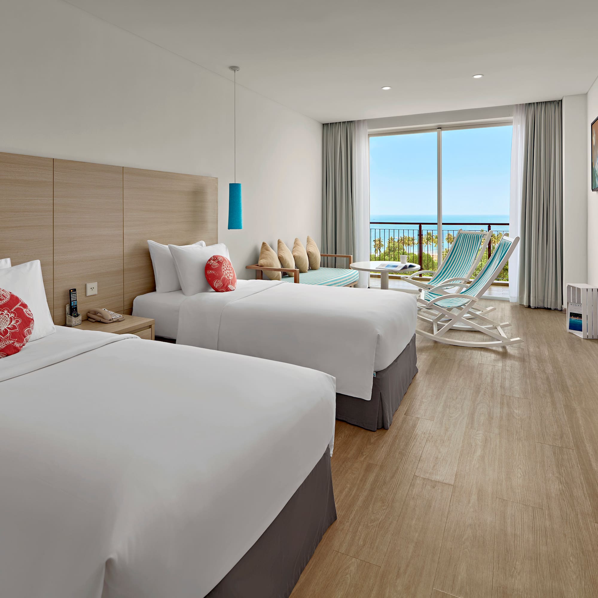 a room with two beds and chairs