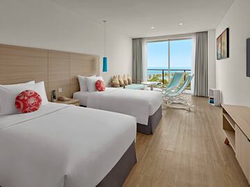 a room with two beds and a chair and a window