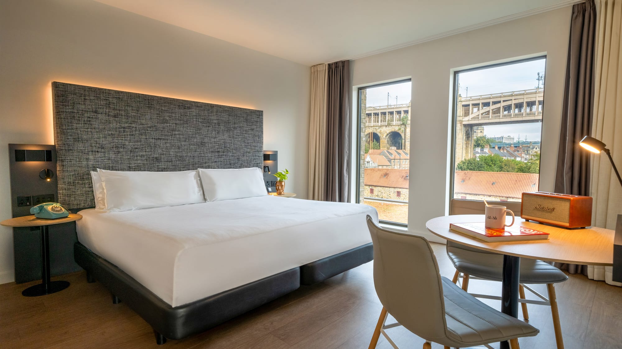 a room with a bed and a table and chairs