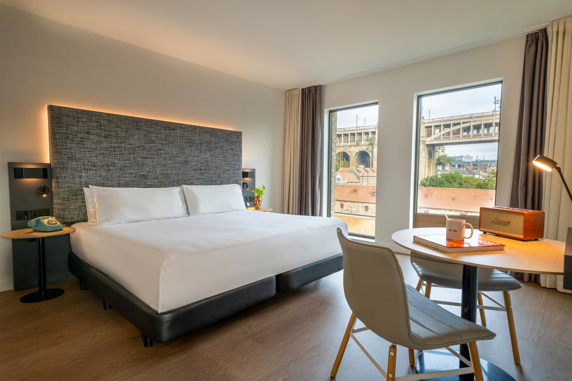 a room with a bed and a table and chairs