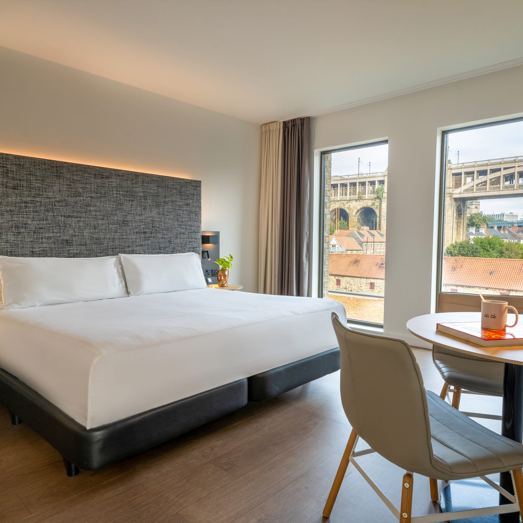 a room with a bed and a table and chairs