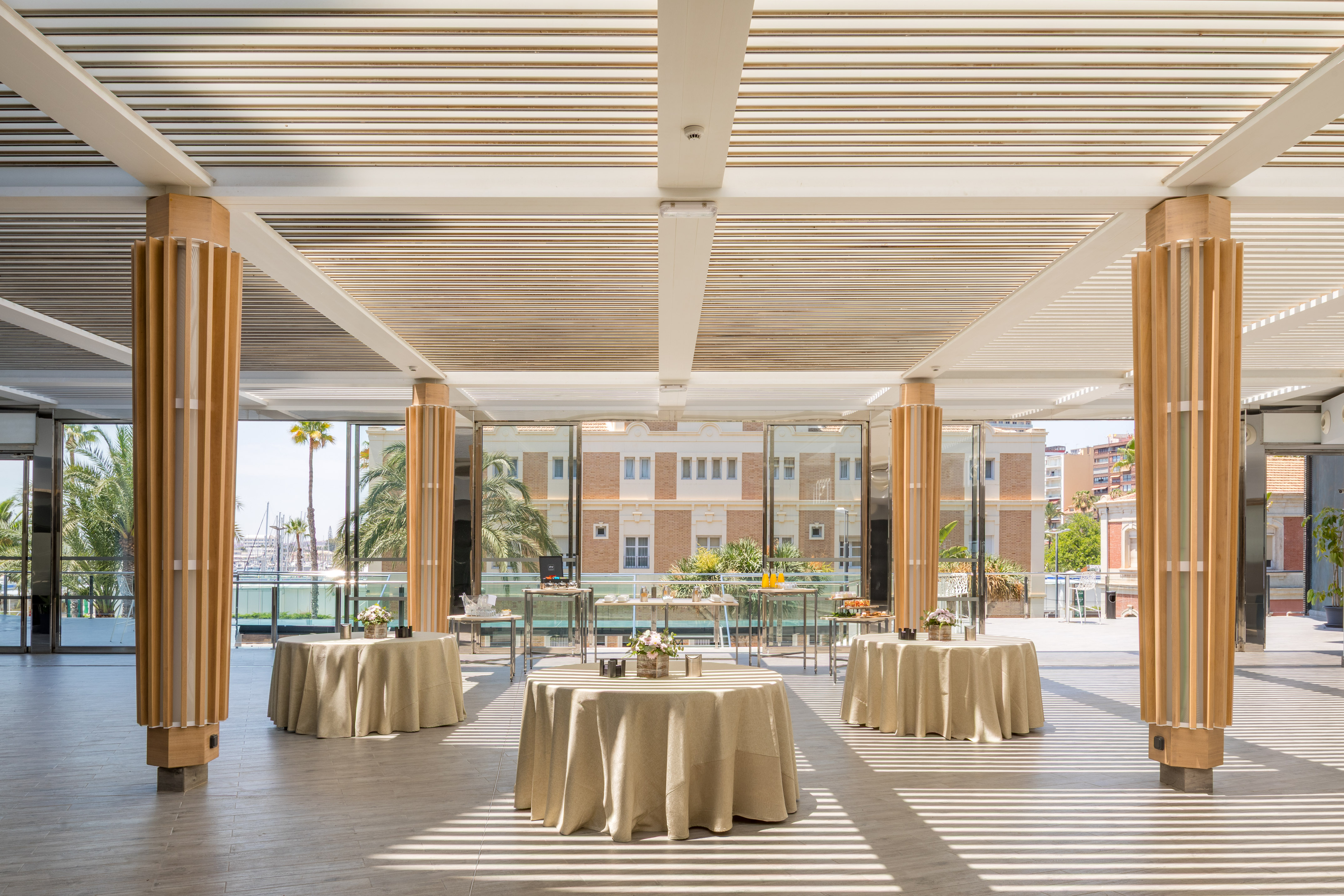 Elegant modern event venue with tables and sunny waterfront view.