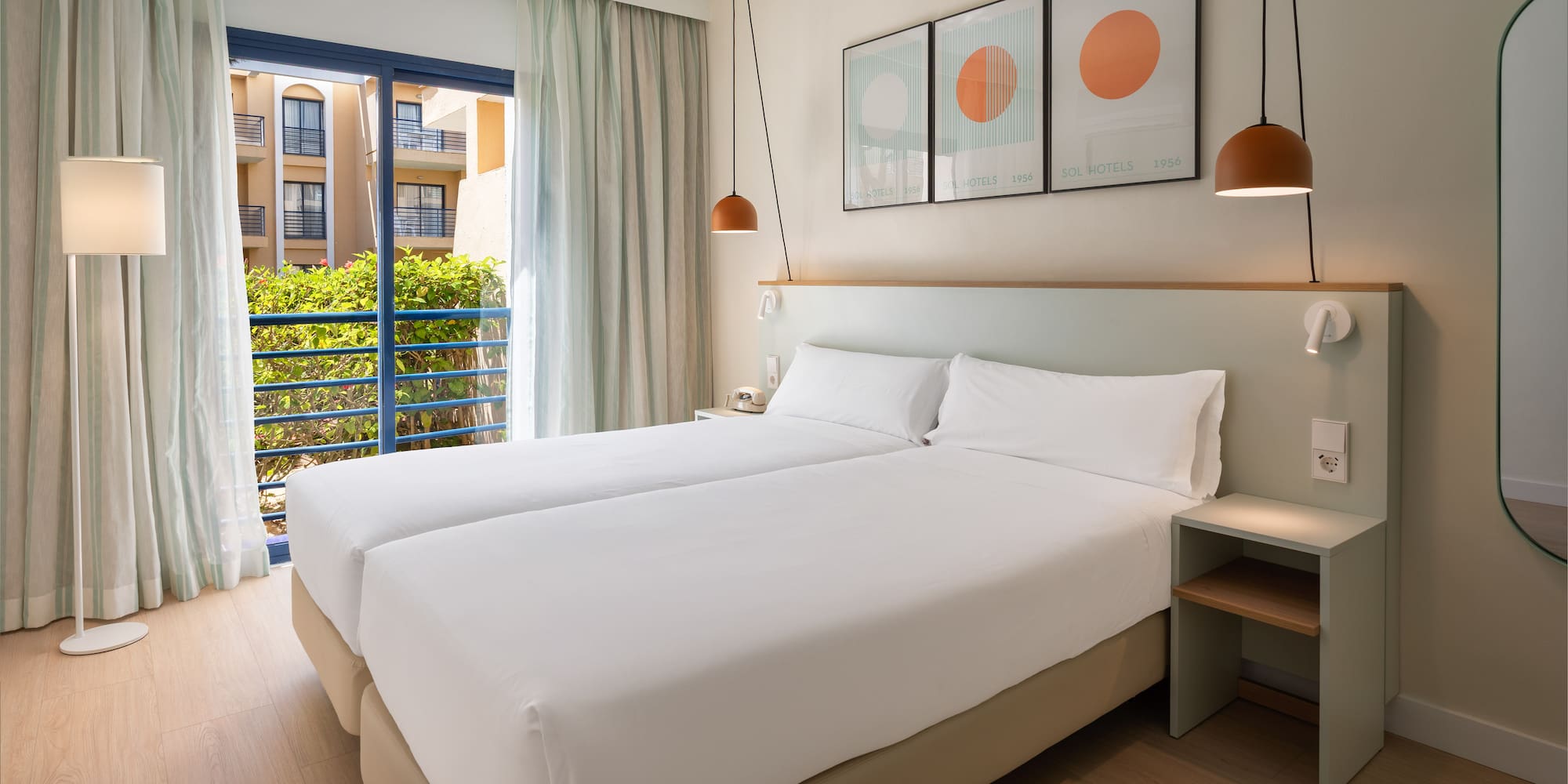 a room with two beds and a balcony