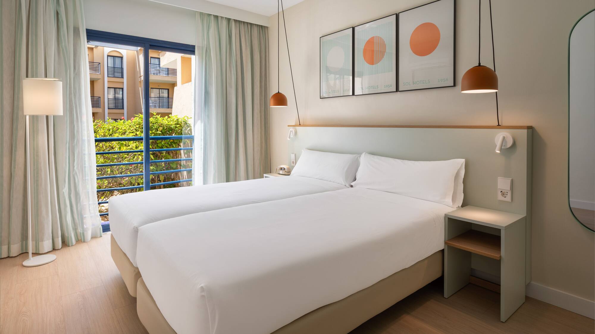 a room with two beds and a balcony