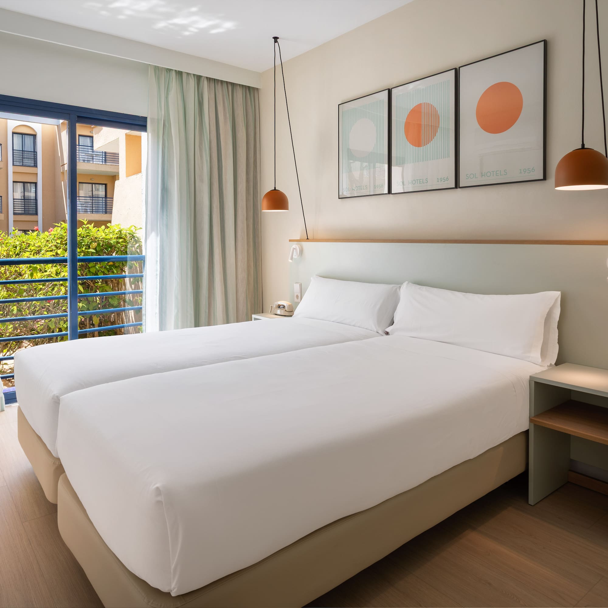 a room with two beds and a balcony