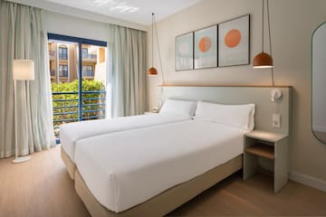 a room with two beds and a balcony