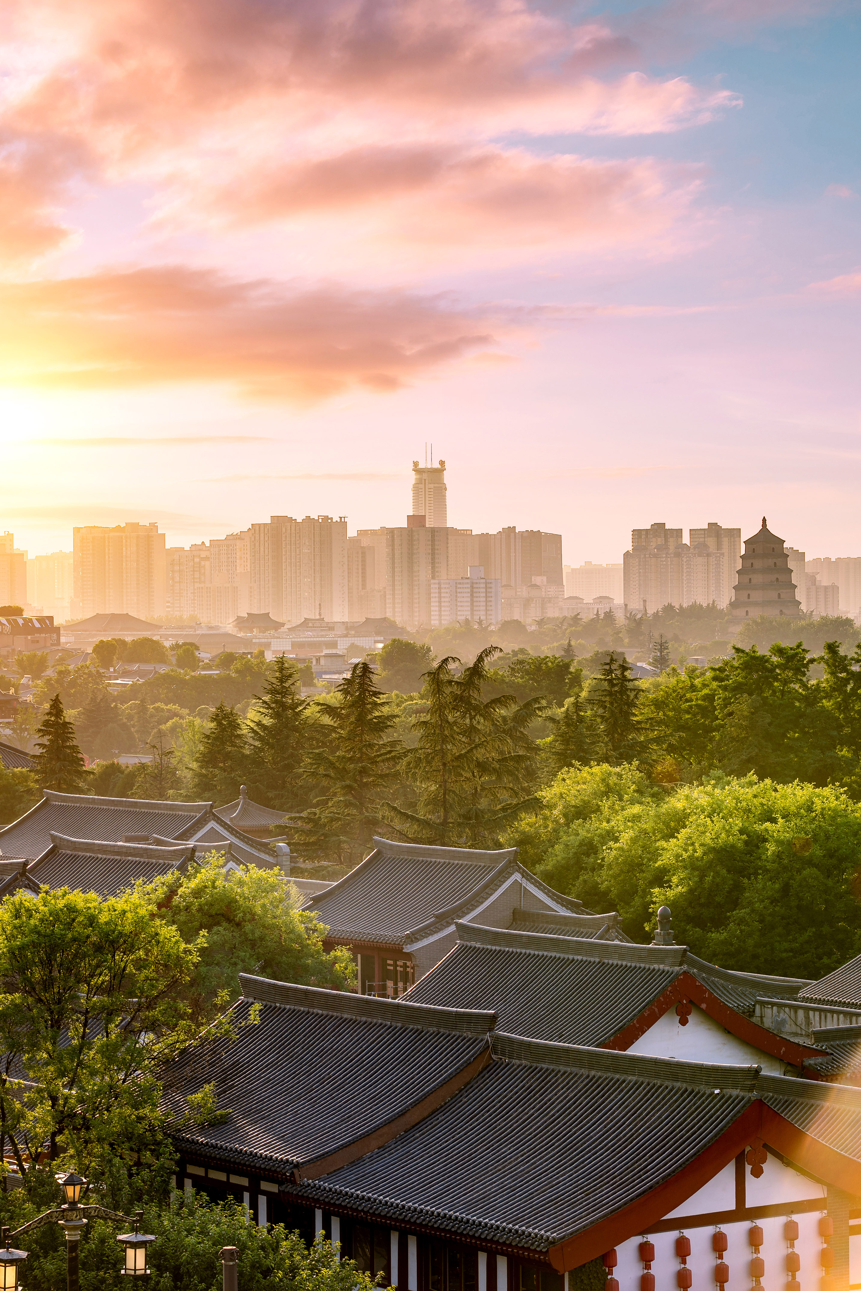 Xi'an sunset: Big Wild Goose Pagoda, traditional roofs, modern skyline.
