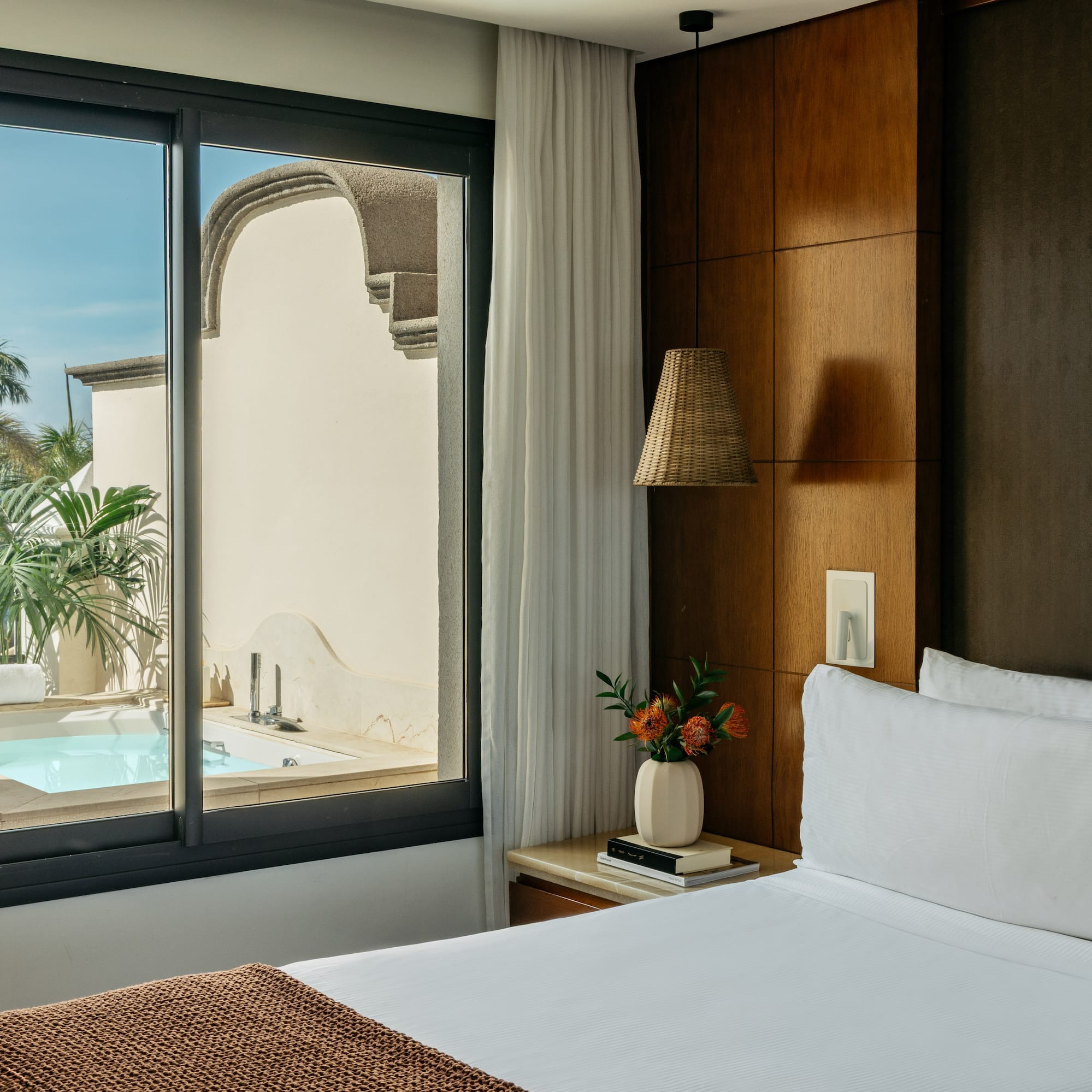 a bed with a window and a pool outside