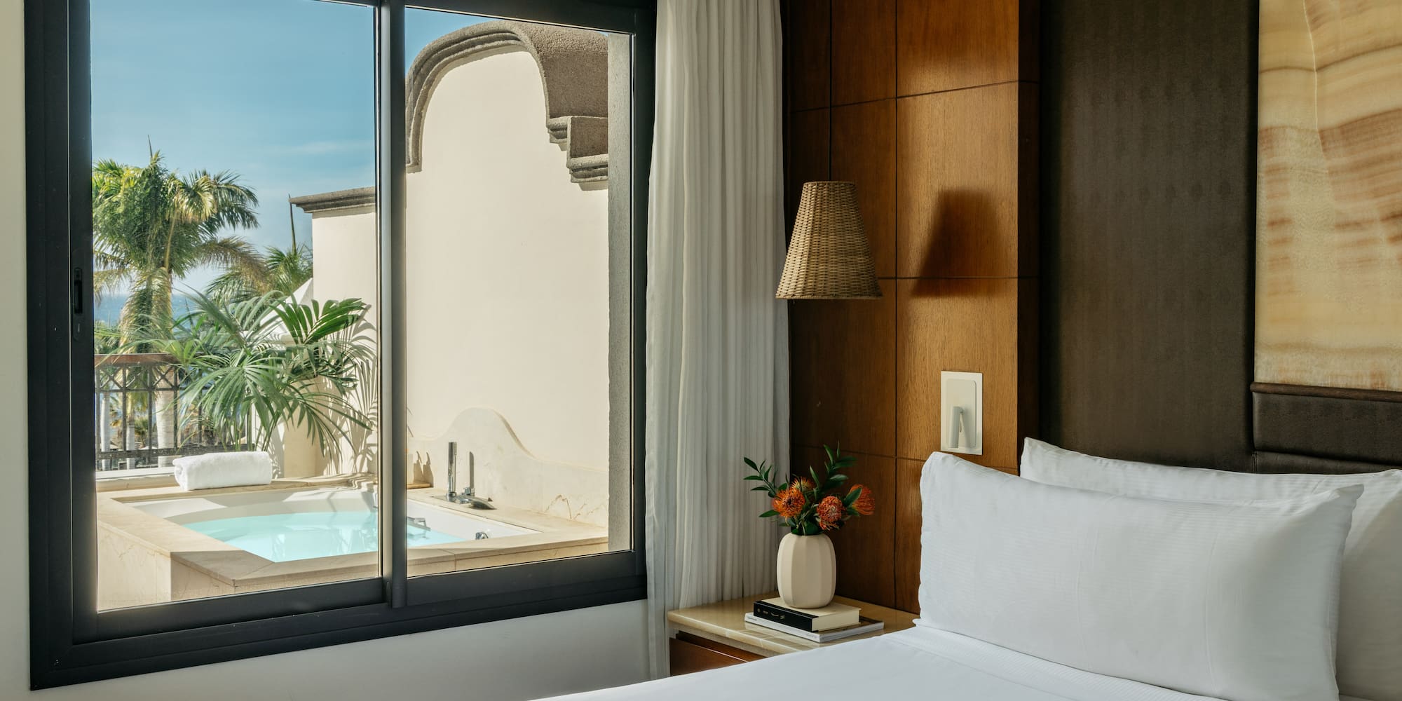 a bed with a window and a pool outside