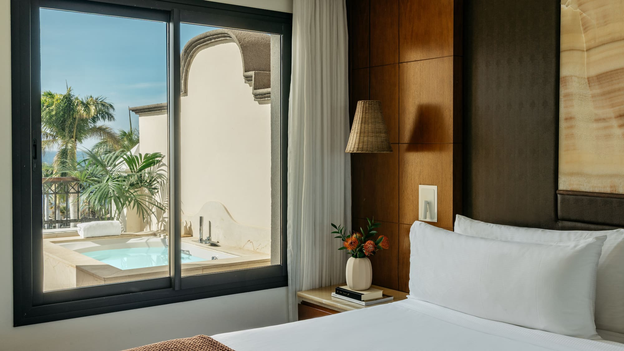 a bed with a window and a pool outside