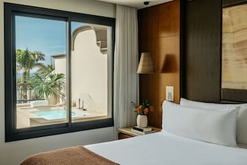 a bed with a window and a pool outside