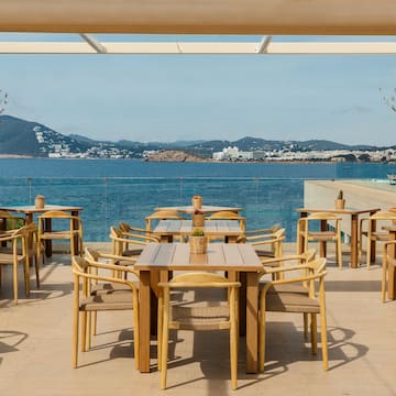 a table and chairs on a deck overlooking a body of water