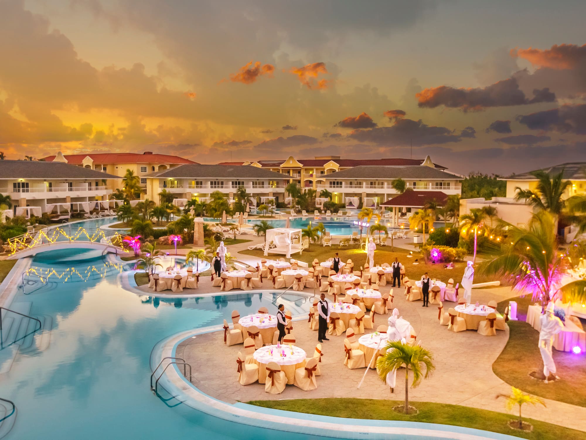 a pool with tables and people around it