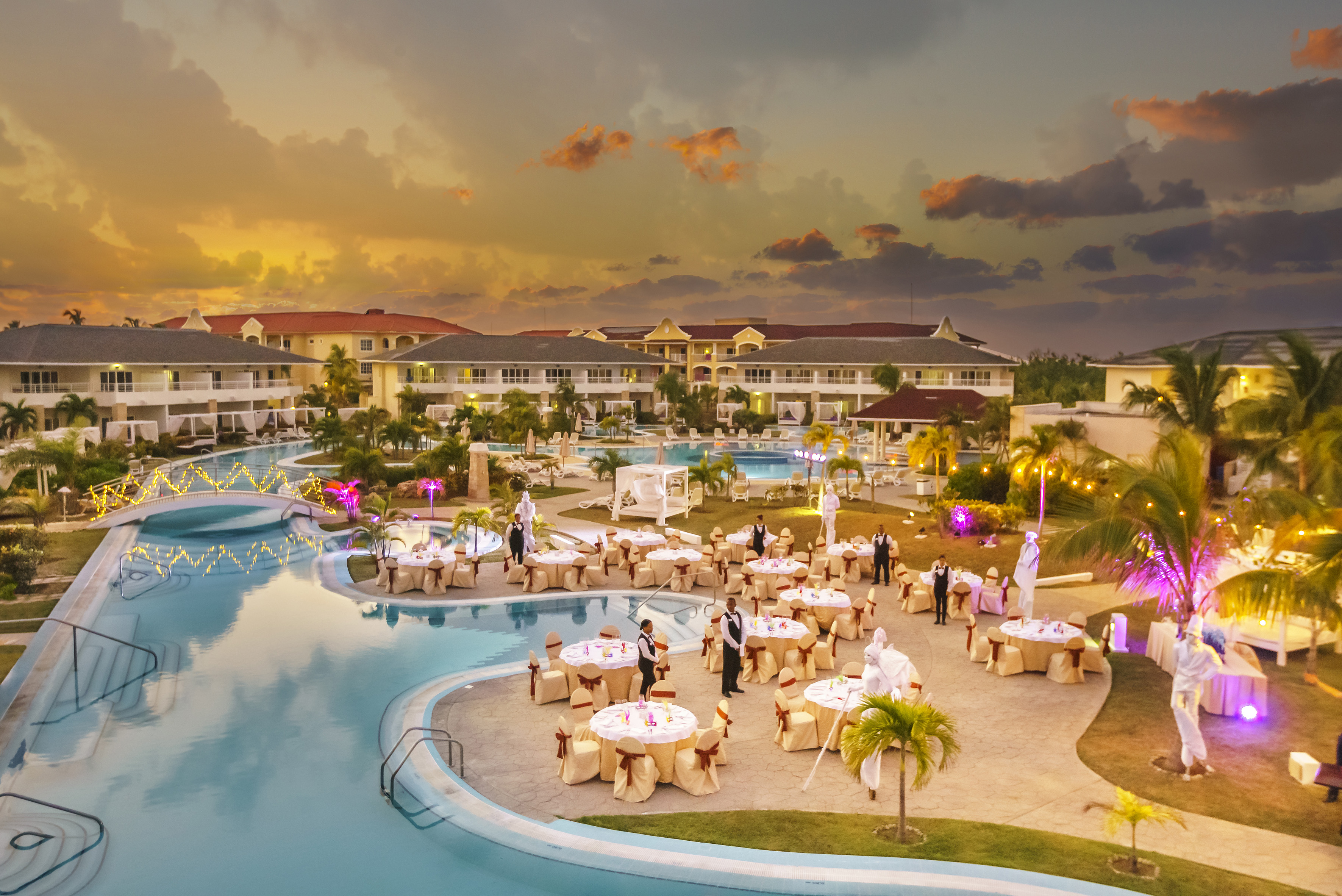 a pool with tables and people around it