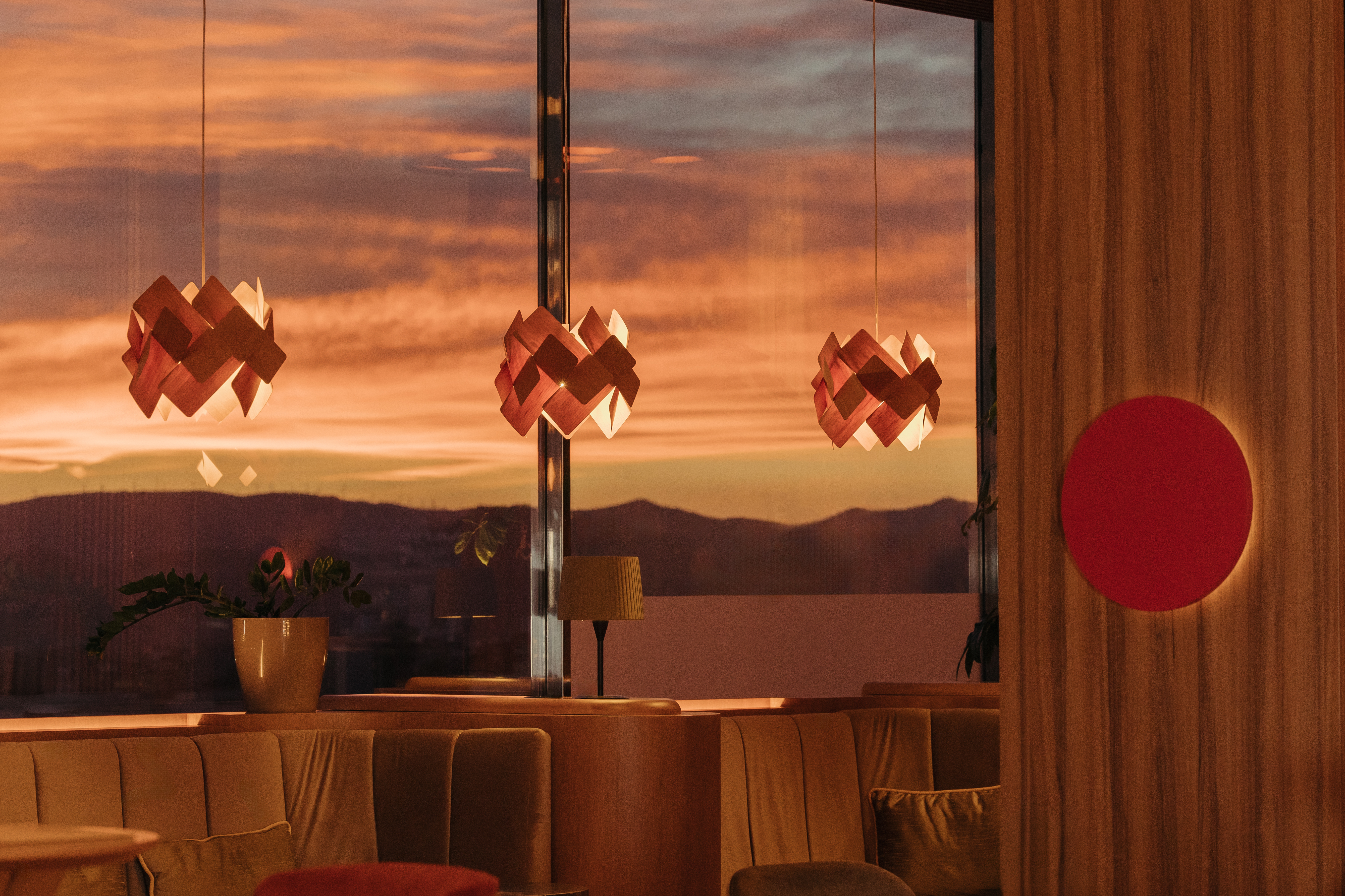 Restaurant lounge with warm sunset views, modern geometric pendant lights.