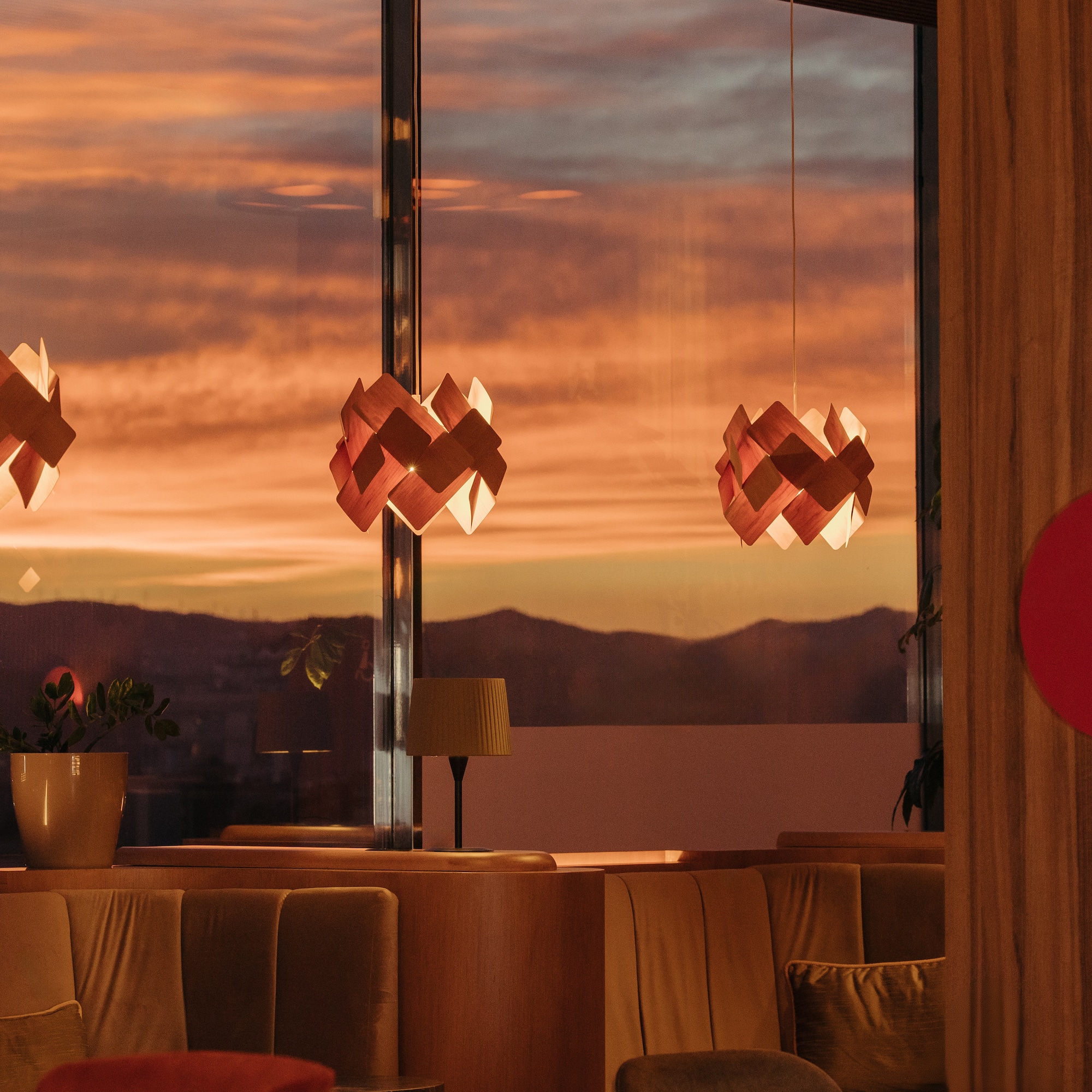 Restaurant lounge with warm sunset views, modern geometric pendant lights.