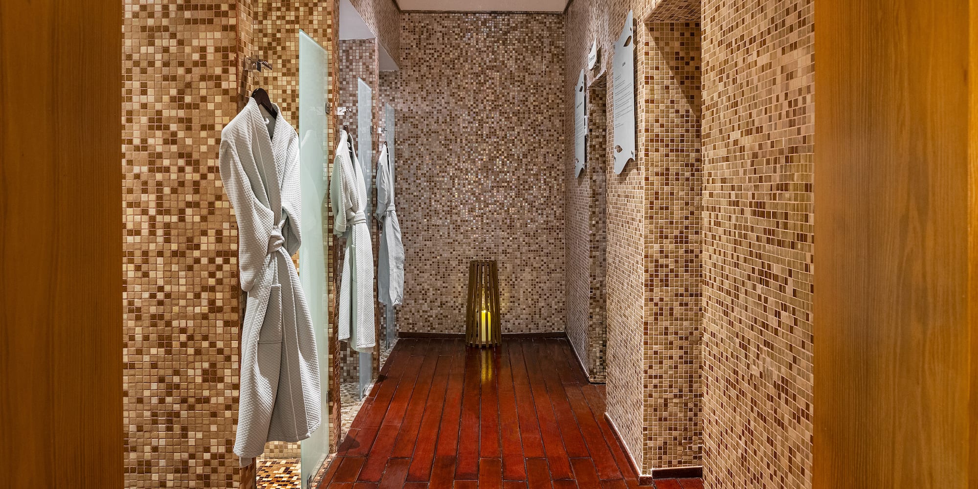 a bathroom with white robes on the wall