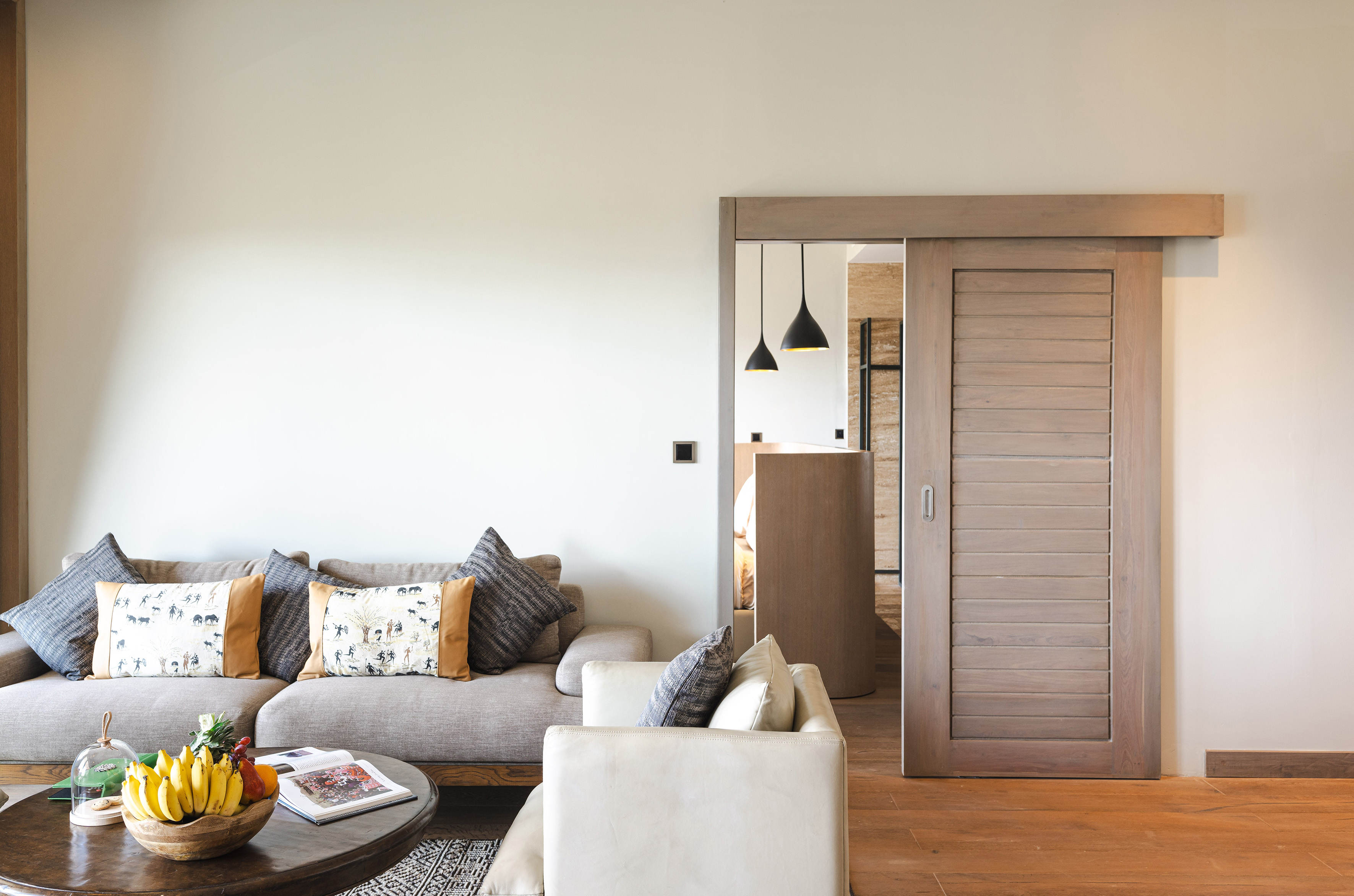Modern living room interior with sofa, coffee table, and open wooden sliding door.
