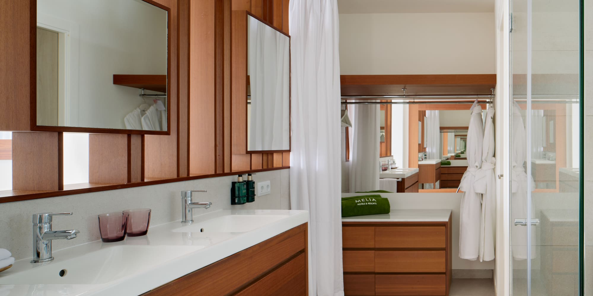 a bathroom with wood cabinets and white towels