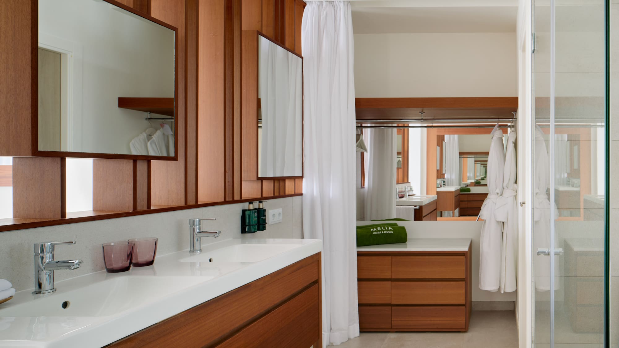 a bathroom with wood cabinets and white towels