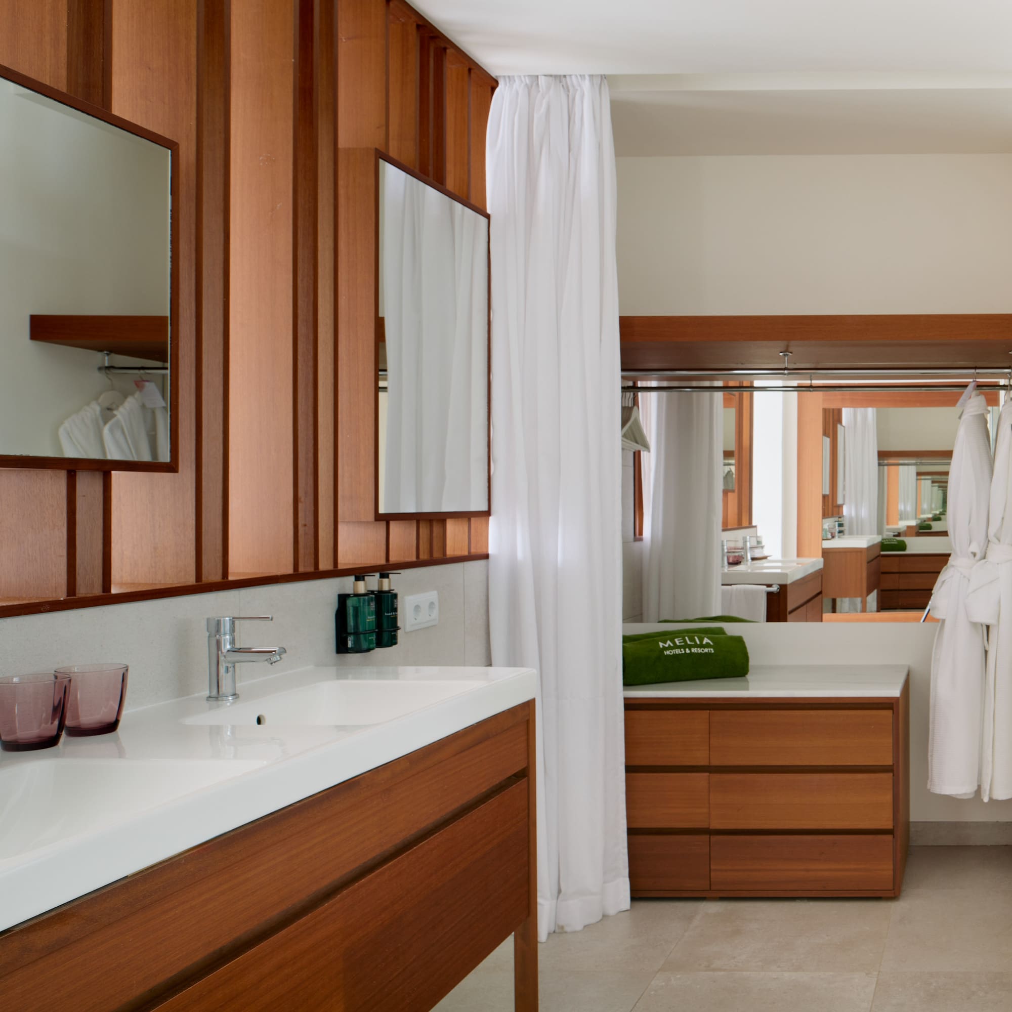 a bathroom with wood cabinets and white towels