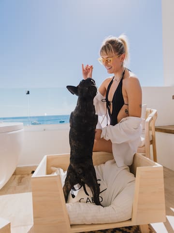 a woman in a swimsuit with a dog on a deck
