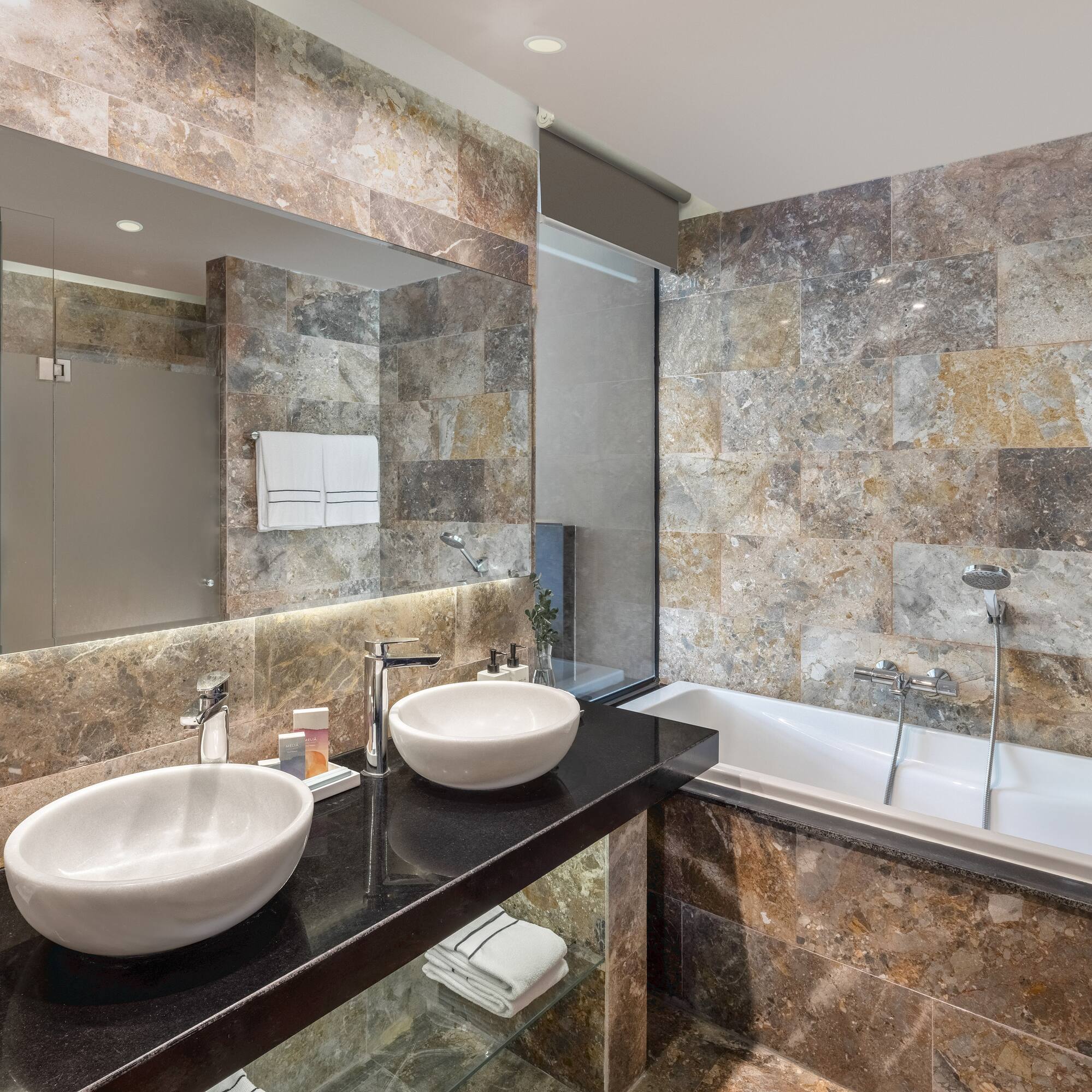 a bathroom with marble tiles and sinks