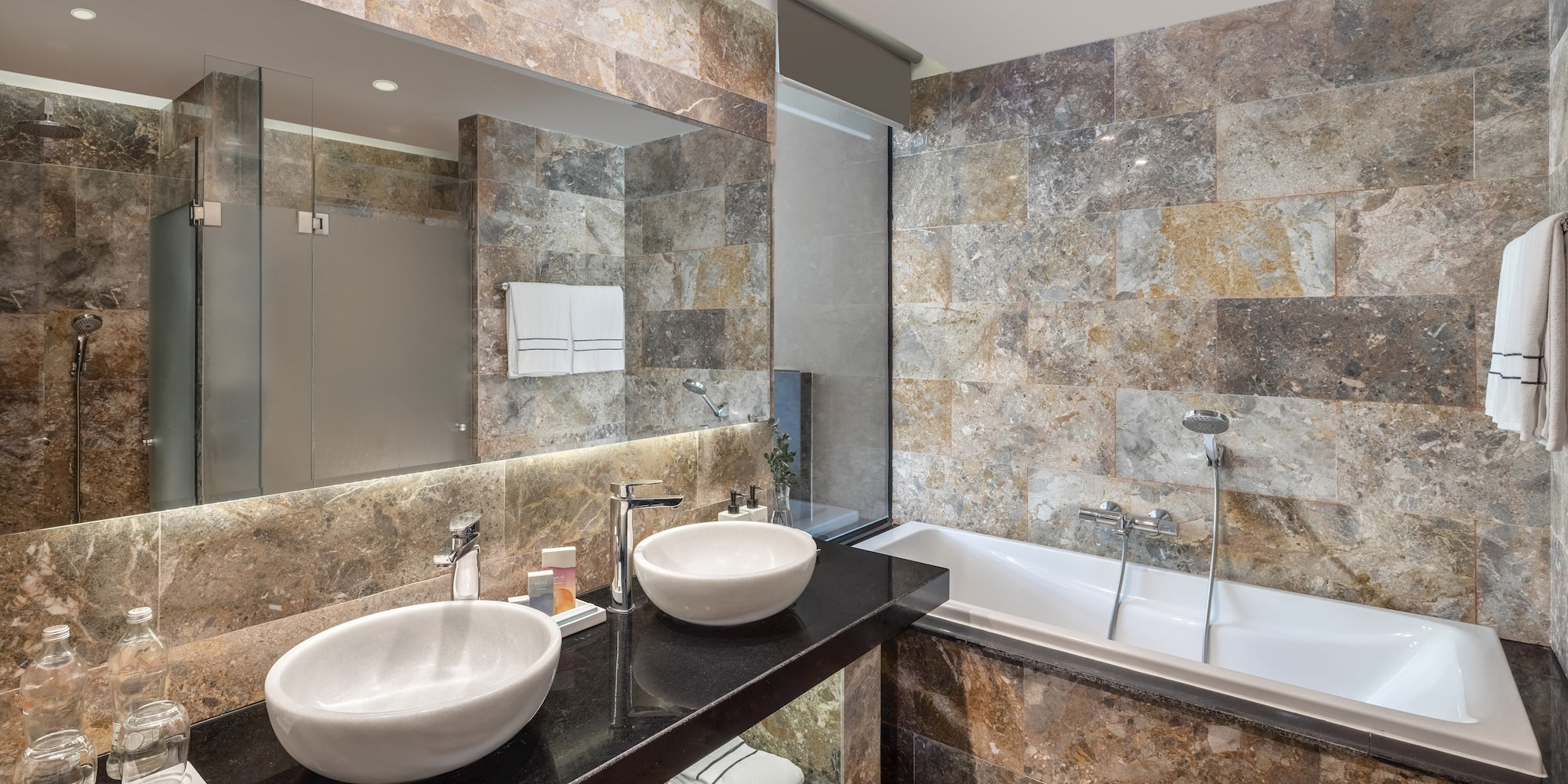 a bathroom with marble tiles and sinks