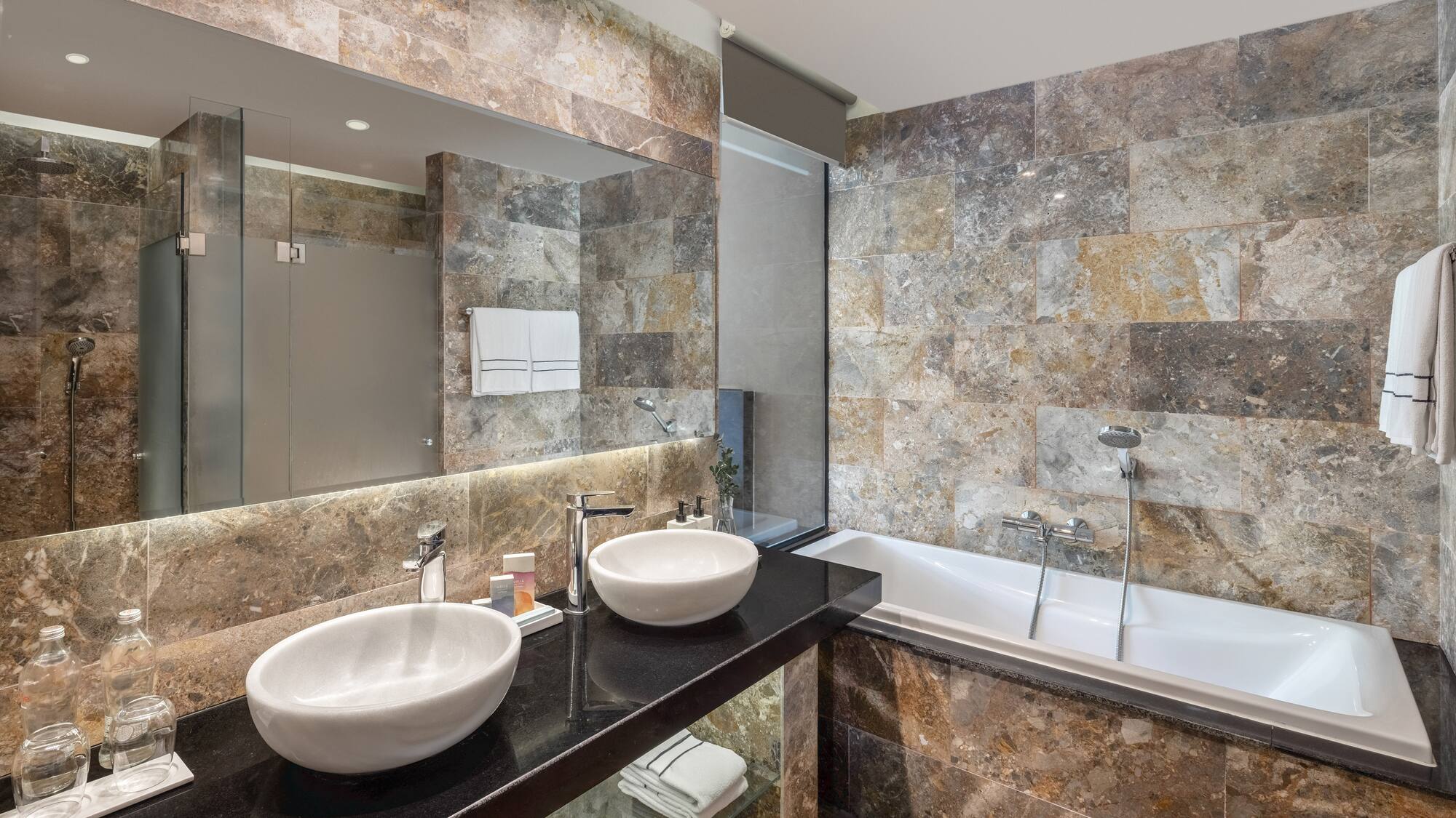 a bathroom with marble tiles and sinks