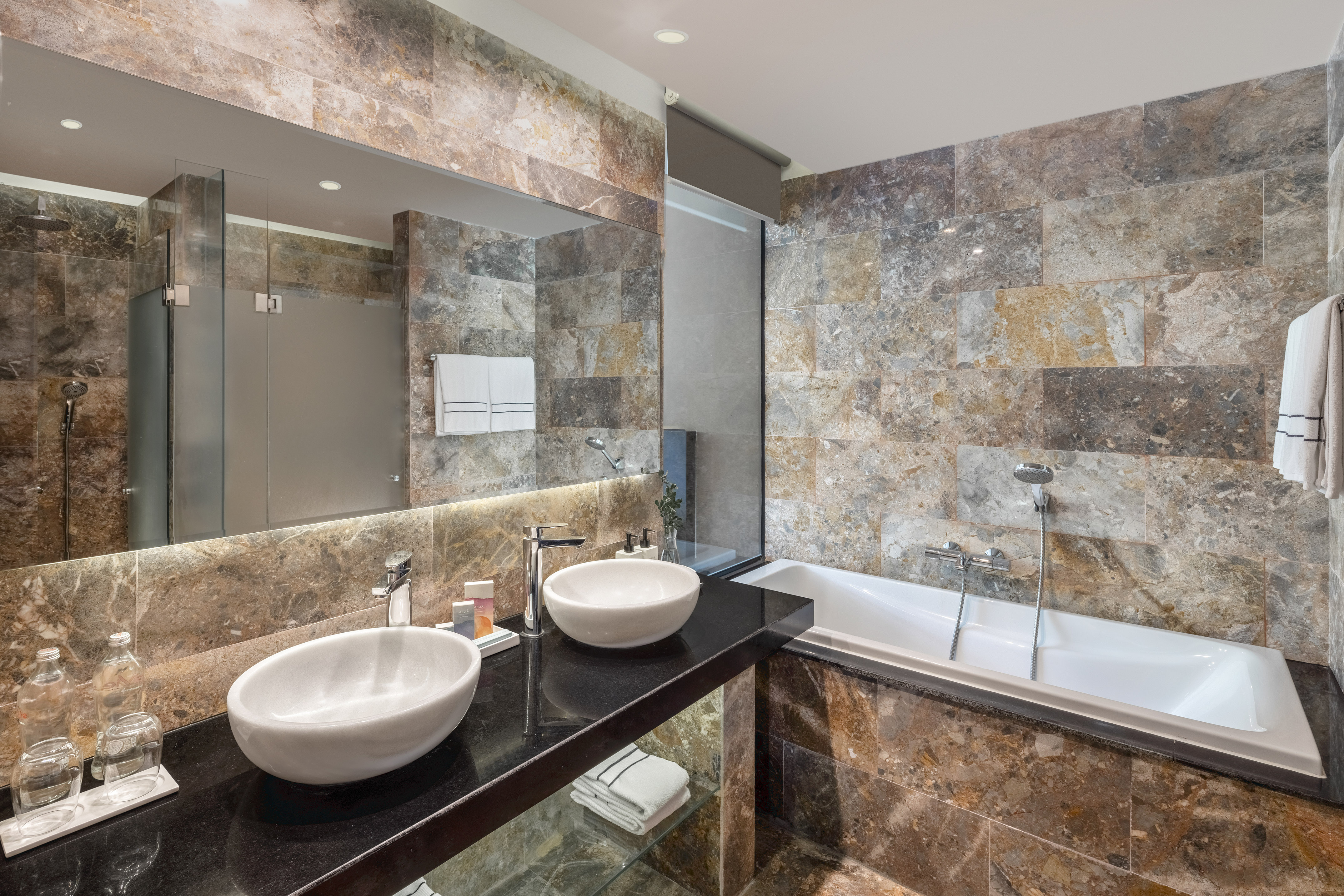 a bathroom with marble tiles and sinks