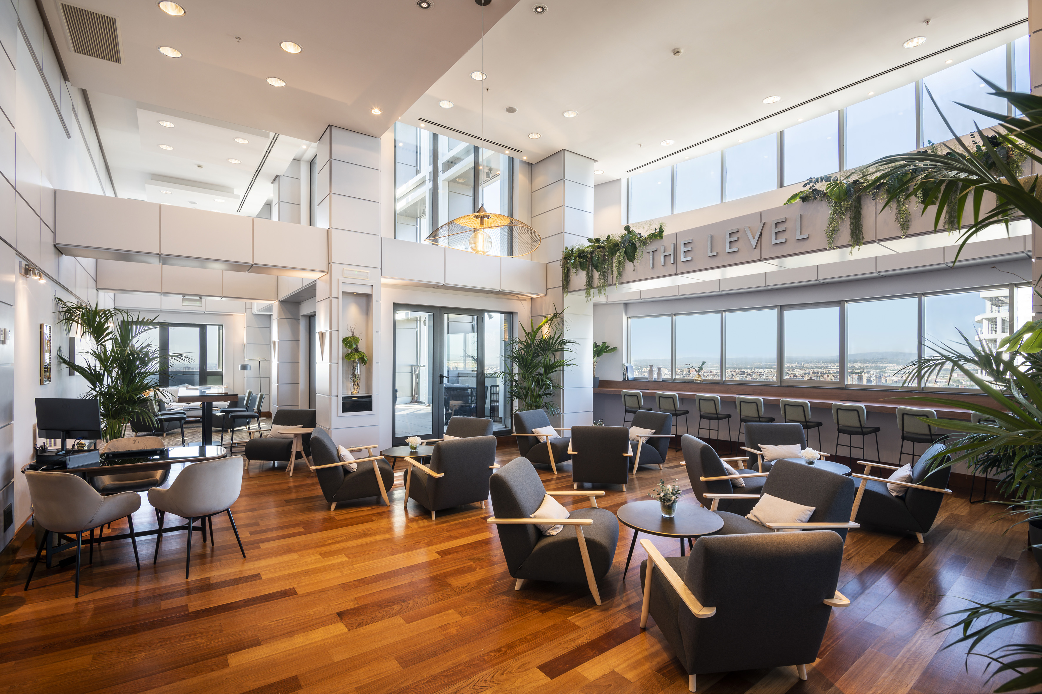 Luxury hotel lounge, modern design, comfortable seating, city views, hardwood.