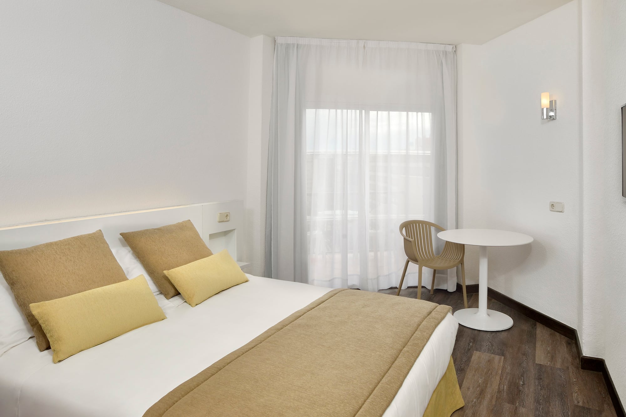 a bed with a table and chairs in a room