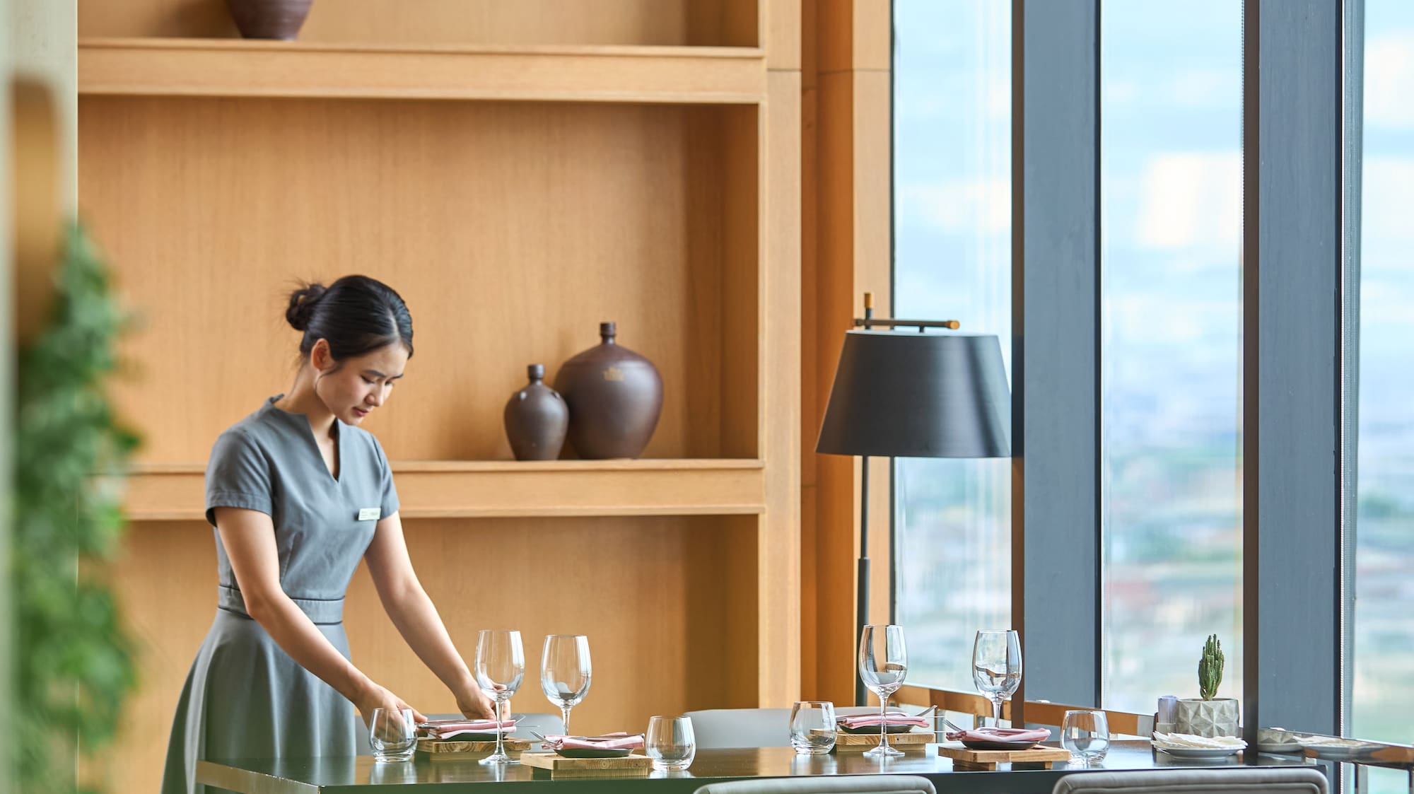 a woman in a grey dress at a table
