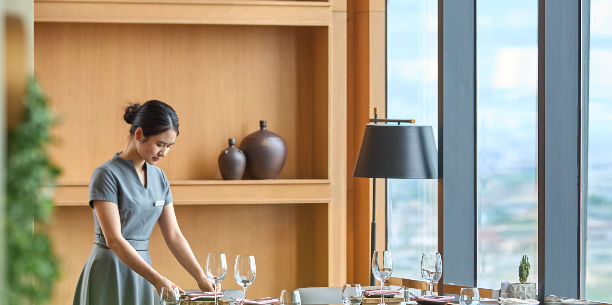 a woman in a grey dress at a table