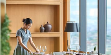 a woman in a grey dress at a table