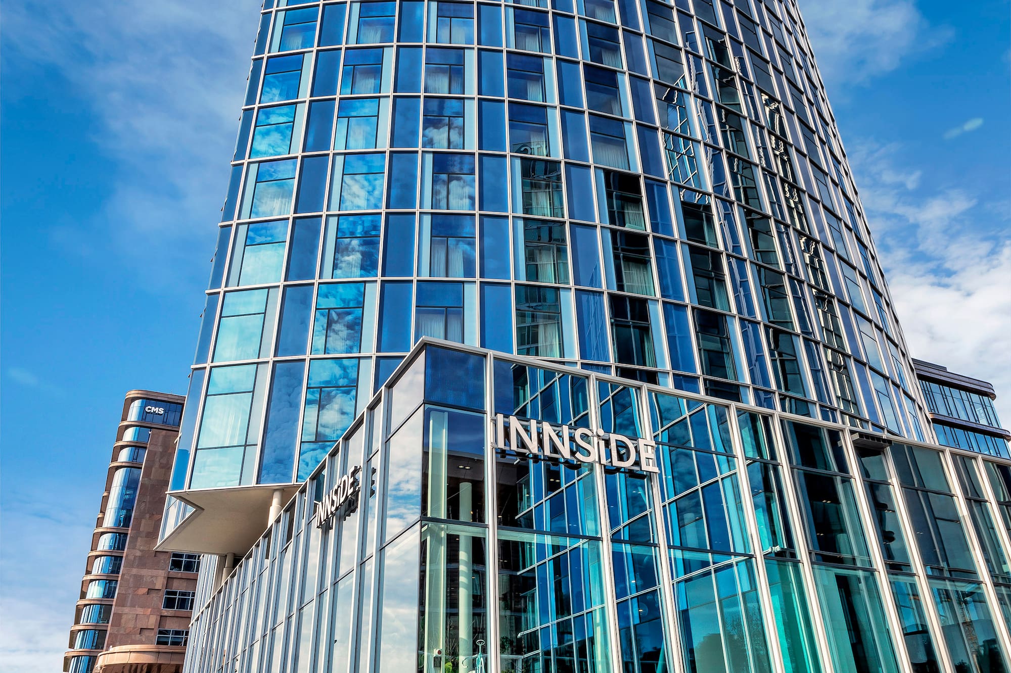 a tall glass building with a blue sky
