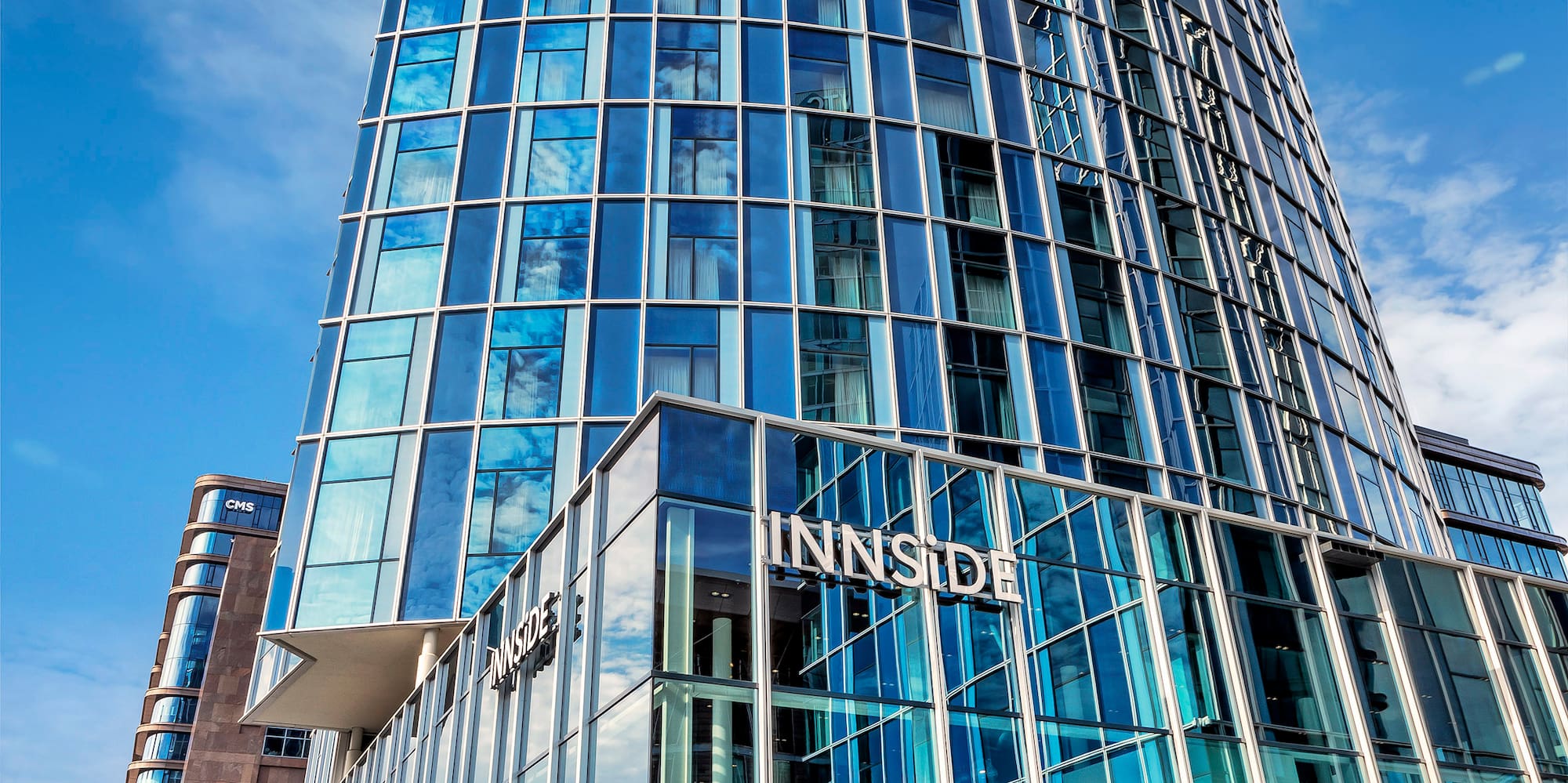 a tall glass building with a blue sky