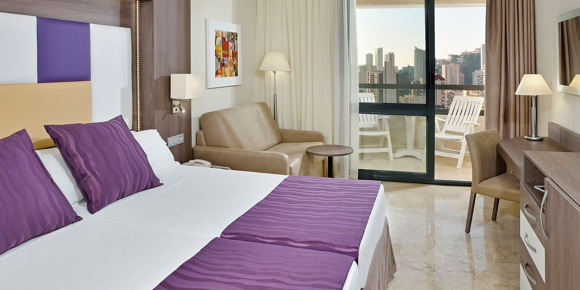 a room with a bed and chairs and a table