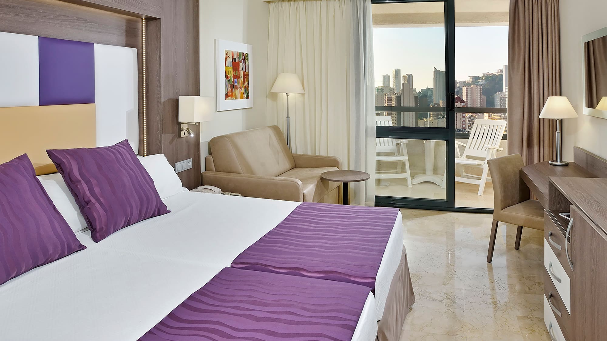 a room with a bed and chairs and a table