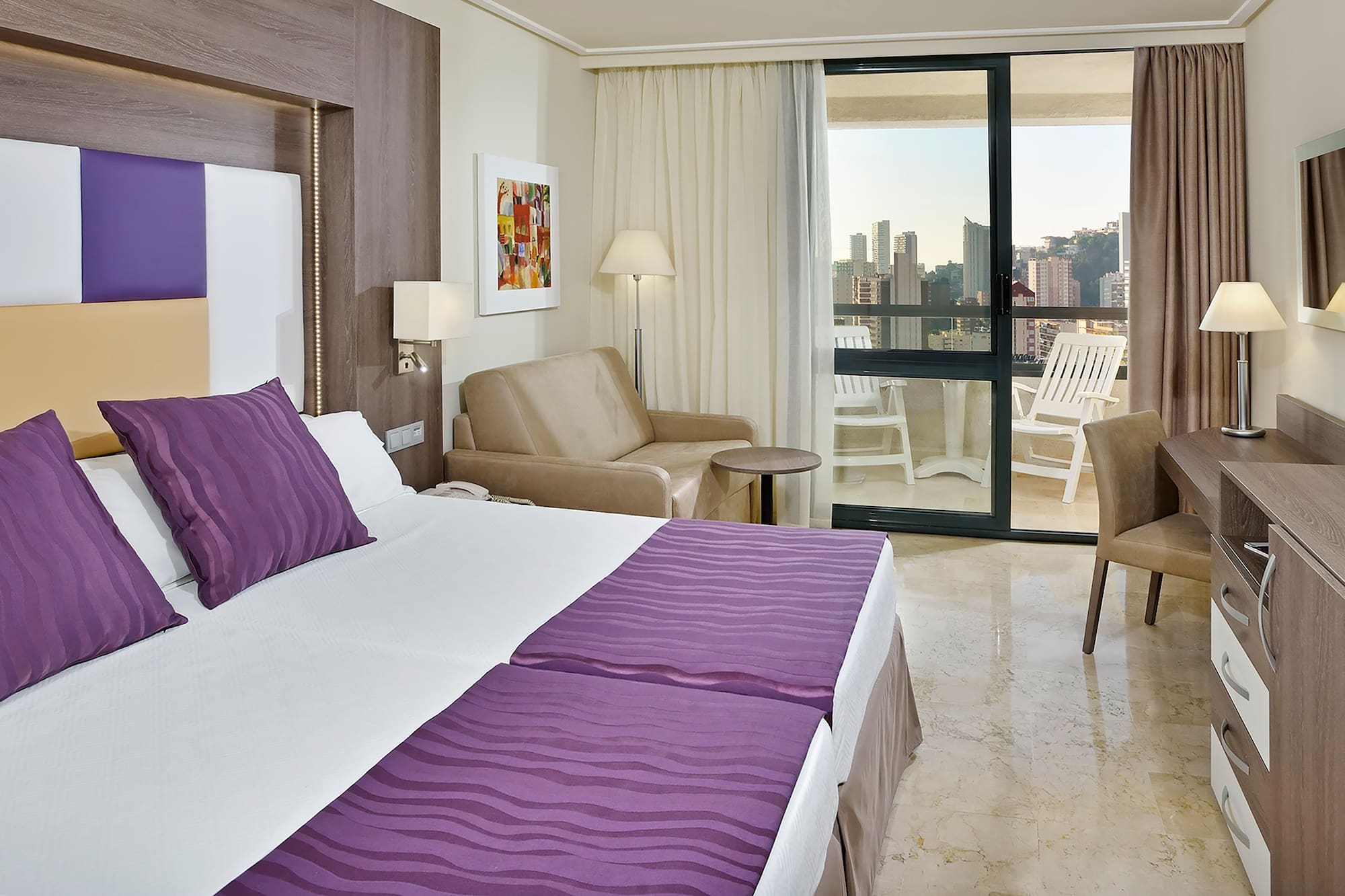 a room with a bed and chairs and a table