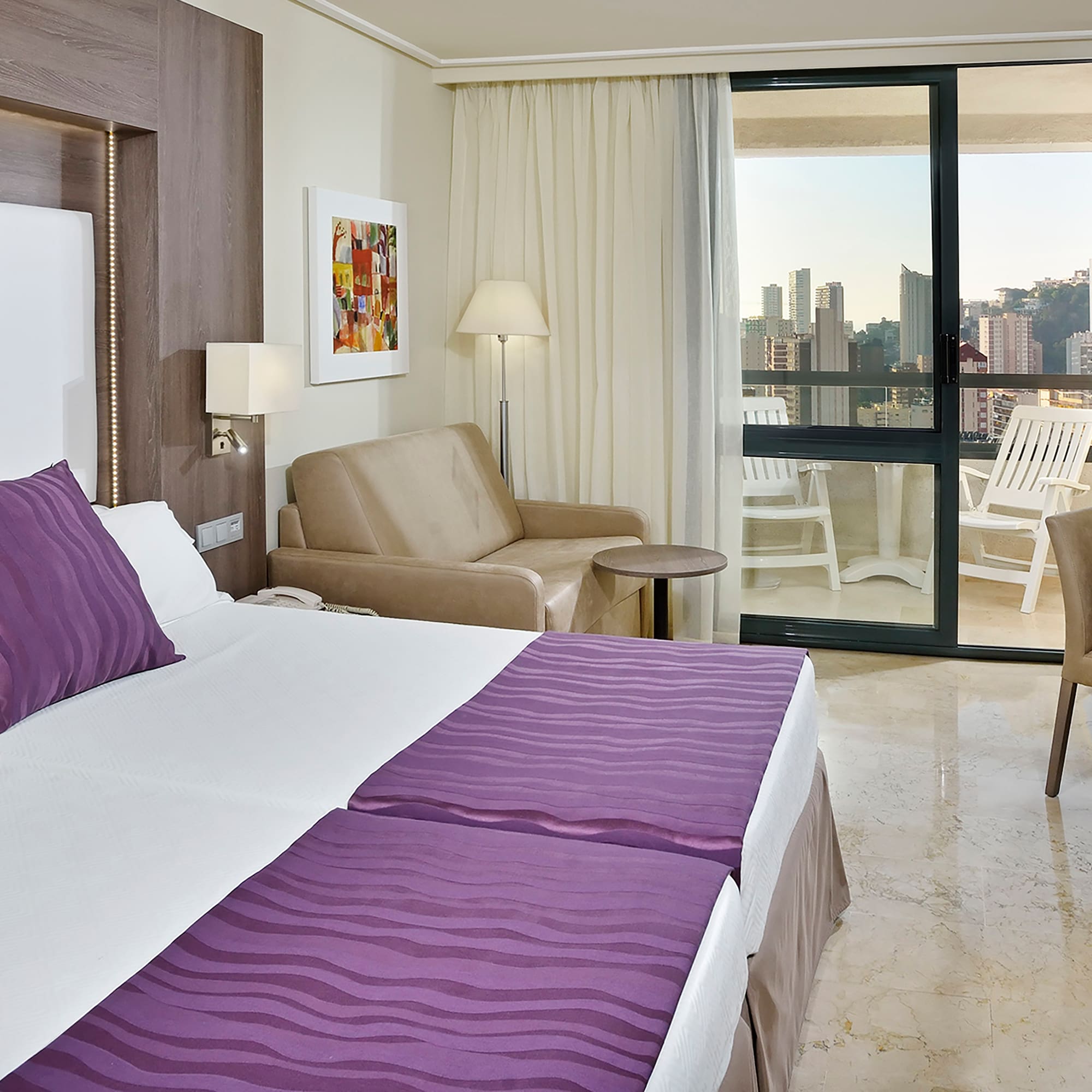 a room with a bed and chairs and a table