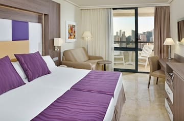 a room with a bed and chairs and a table